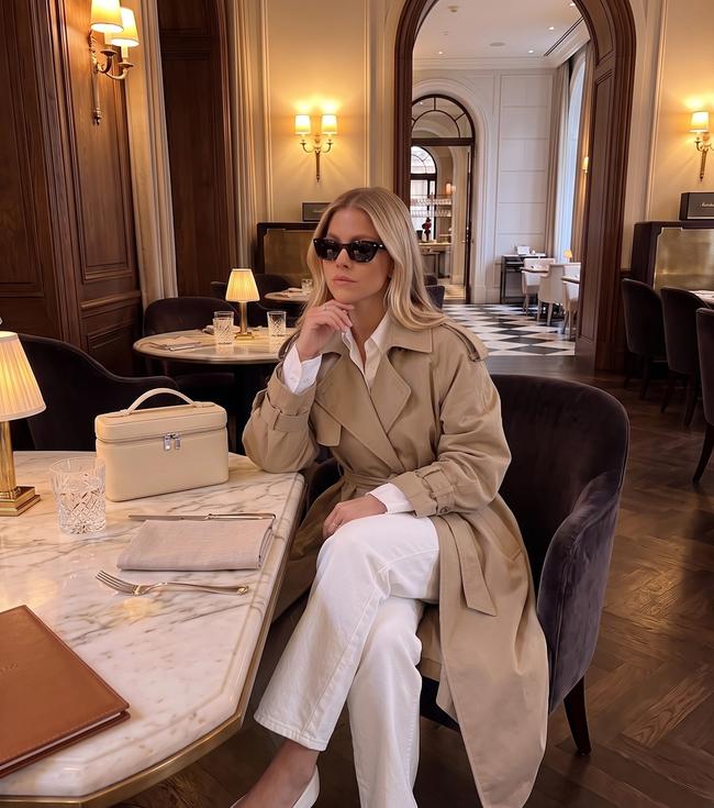 Woman modeling a casual fall quiet luxury monochromatic outfit consisting of a cream collared knit sweater, white jeans and beige ballet flats.