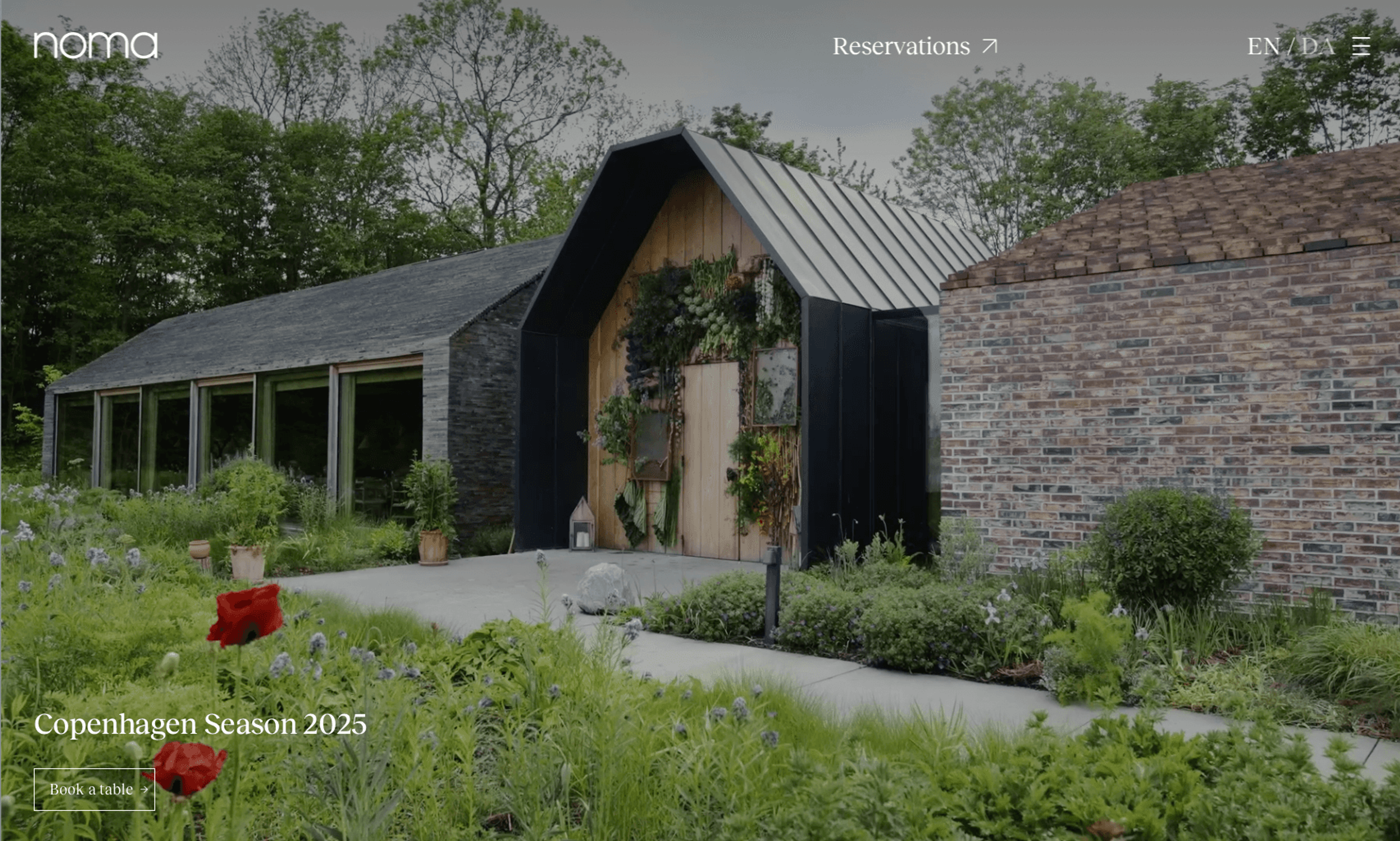 Noma Copenhagen website hero showing the restaurant entrance surrounded by gardens