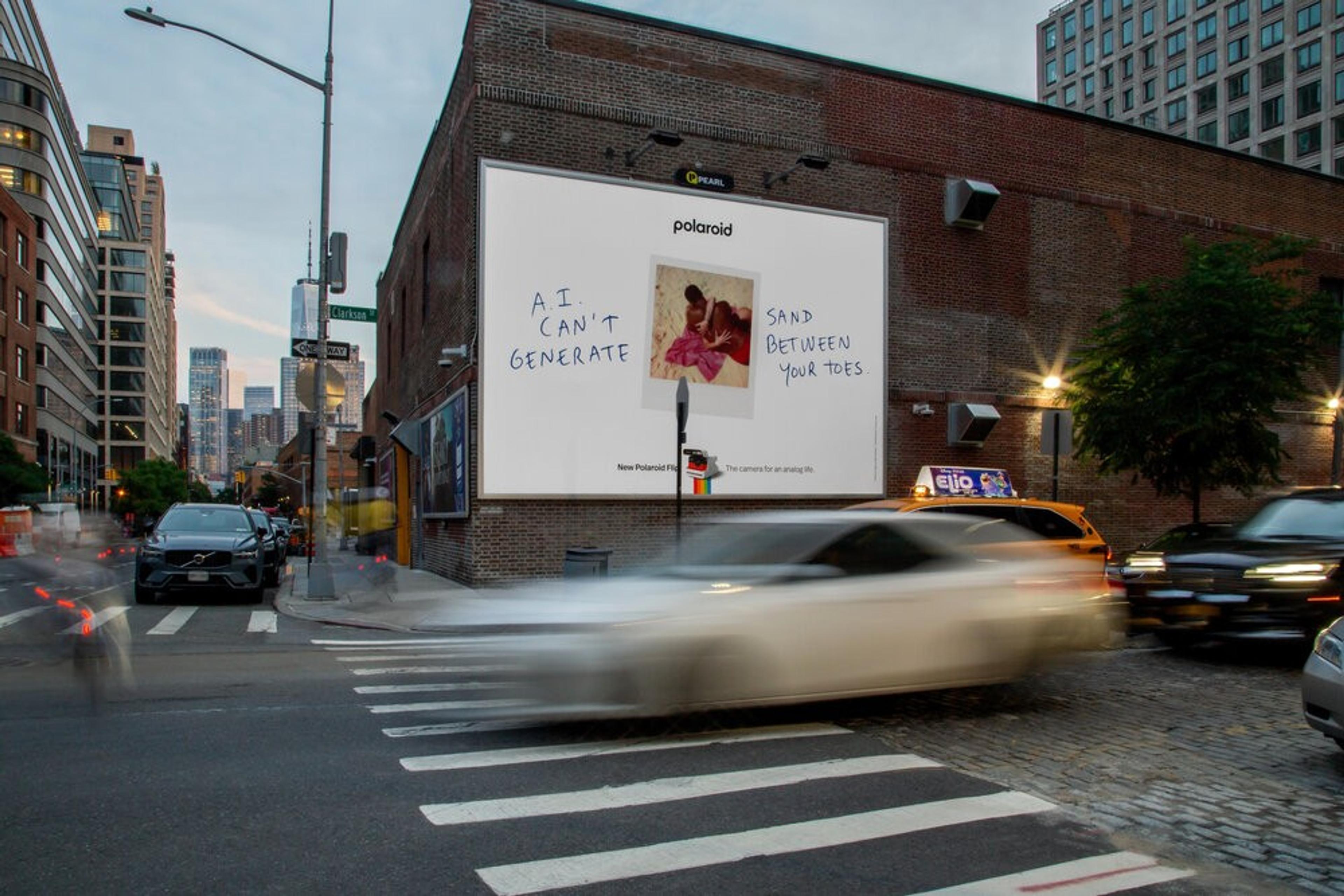 Polaroid billboard on a busy city street reading “AI can’t generate sand between your toes,” highlighting the limits of AI versus real life