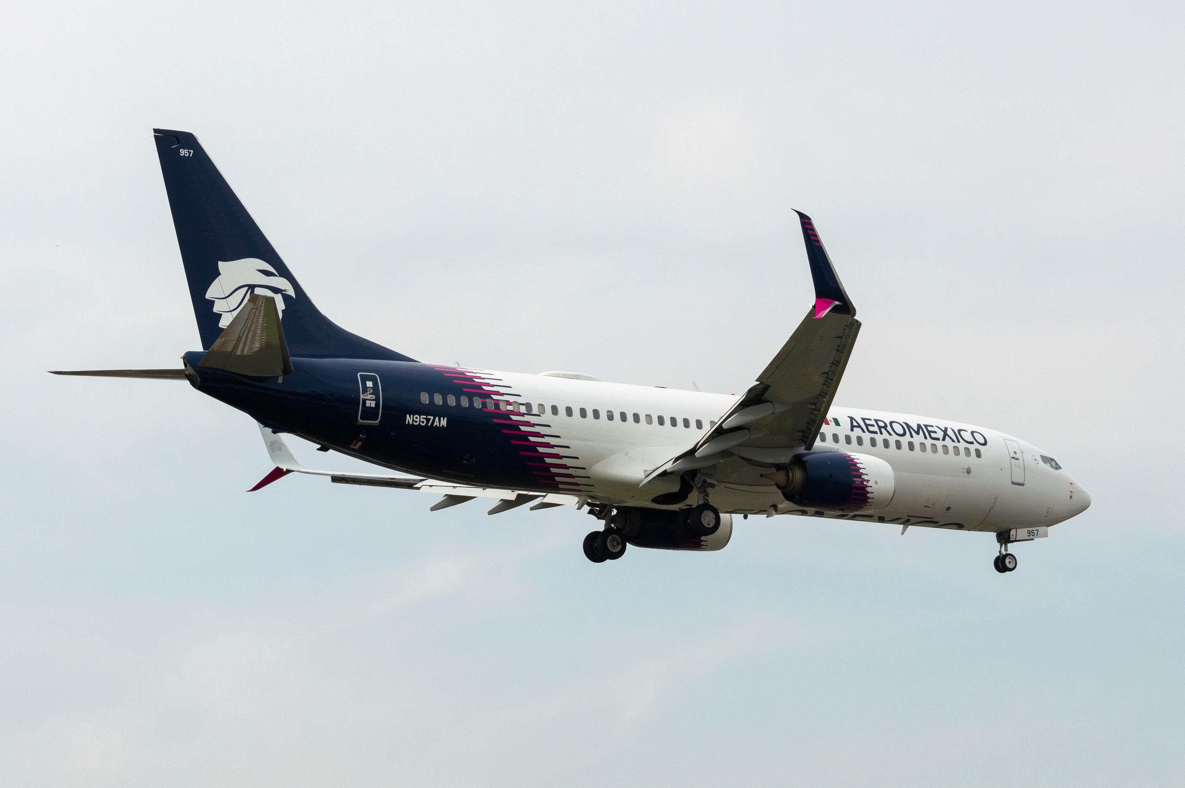 Aeromexico Boeing 737 in flight featuring the 2024 dark blue and magenta livery with enlarged tail logo