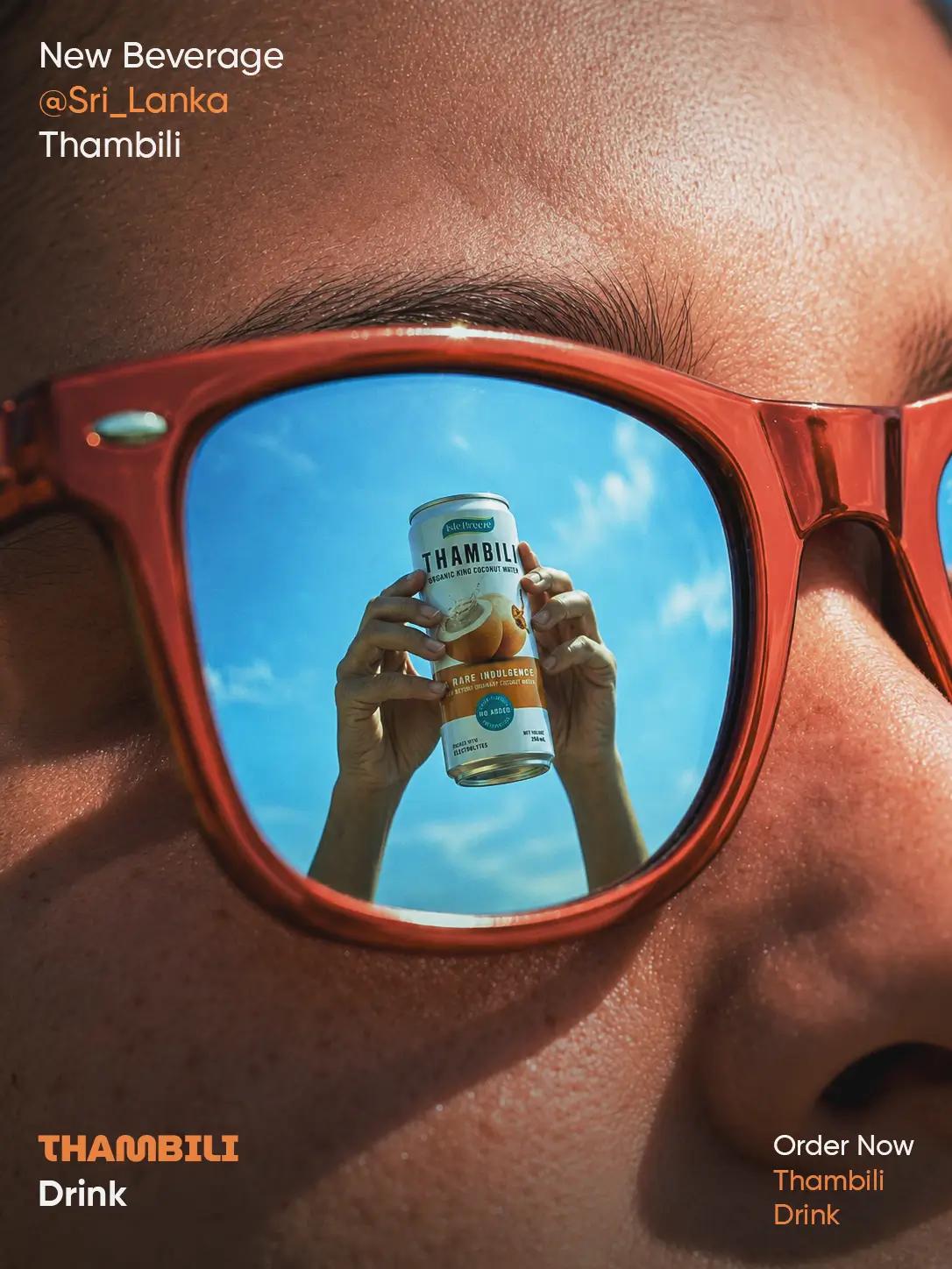Sri Lankan Thambili beverage advertisement featuring a king coconut drink can reflected in red sunglasses against a bright blue sky.