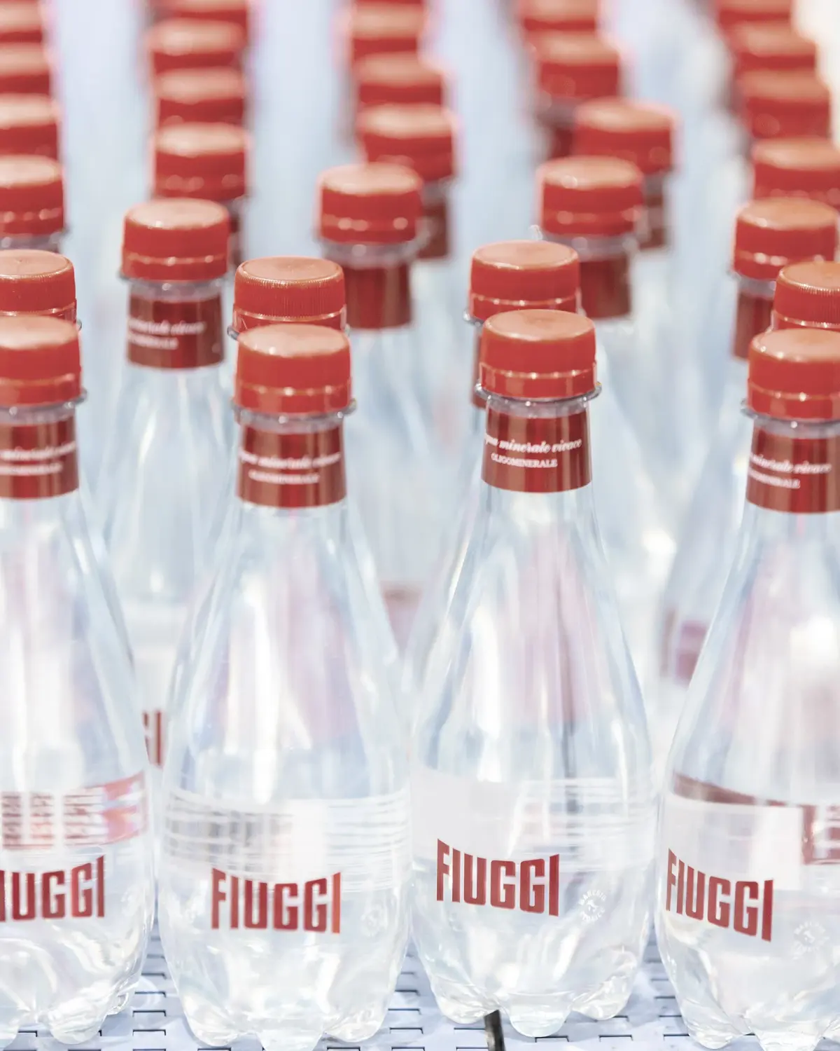 Bottiglie Acqua Fiuggi Premium con tappo rosso sulla linea di produzione