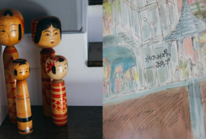 Split image showing four traditional Japanese kokeshi dolls standing on a wooden surface beside a staircase on the left, and a close-up of a colorful, sketchy watercolor illustration of a city scene with buildings and people on the right.