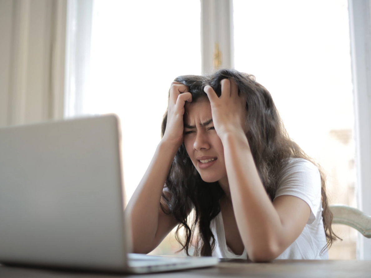 Teenagerin im Stress und überfordert vor ihrem Laptop