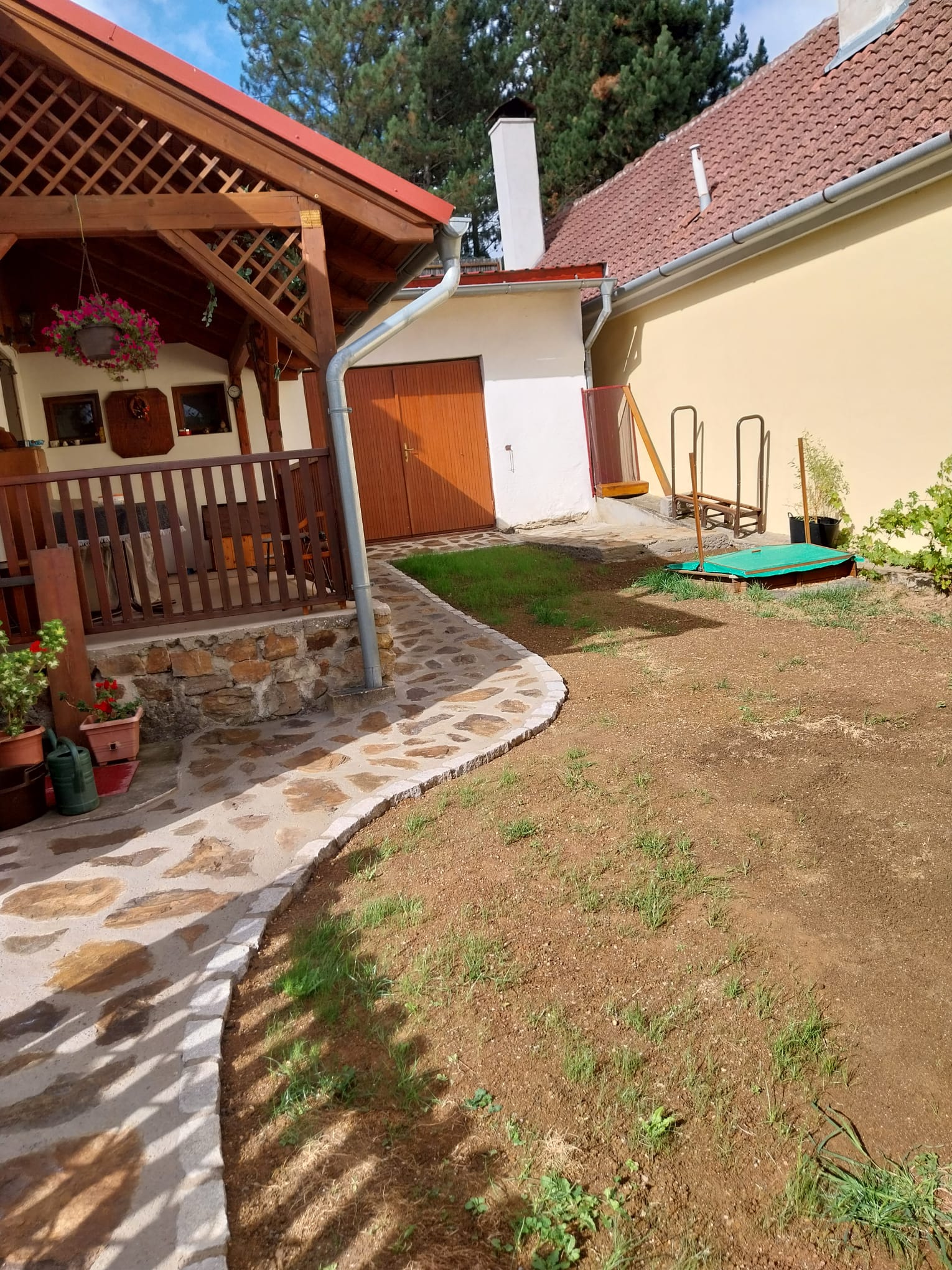 Dokončená zahrada s pergolou a kamennou dlažbou