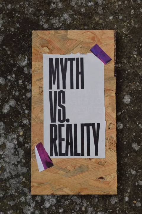 A paper sign reading MYTH VS. REALITY taped to a wooden board, illustrating the misconception that there are no good matches left when dating apps actually just reduce visibility for users over 30