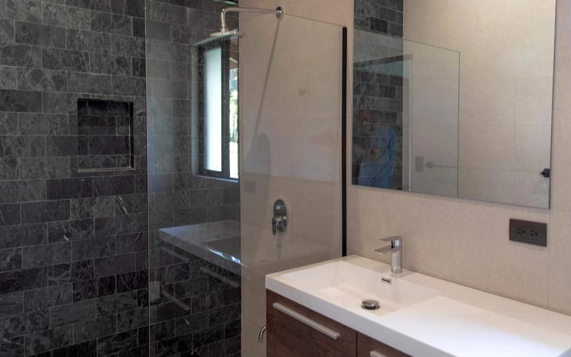 Full bathroom with natural-stone surfaces and quality finishes.