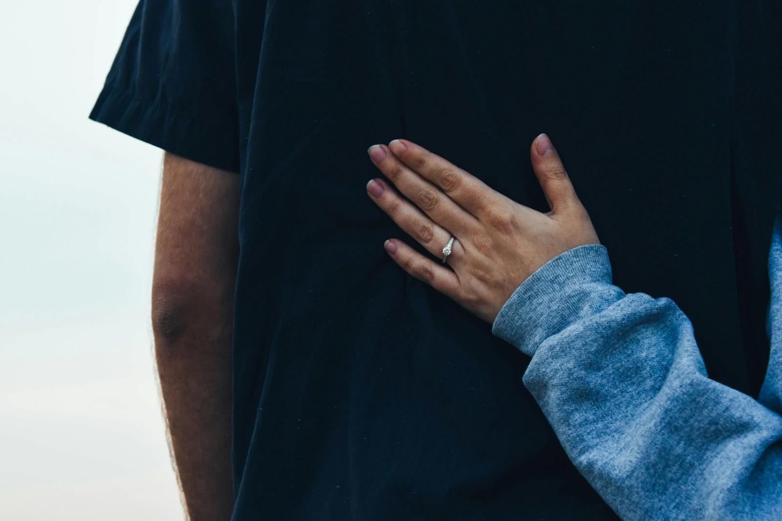 One person resting a supportive hand on another's shoulder.