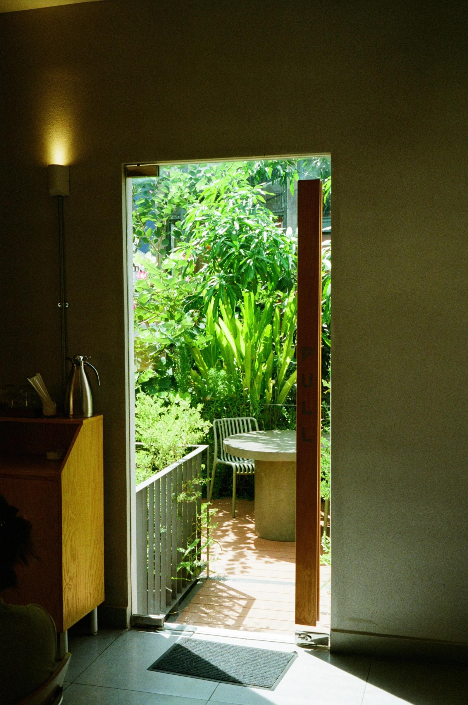 An open doorway framing a lush green garden beyond.