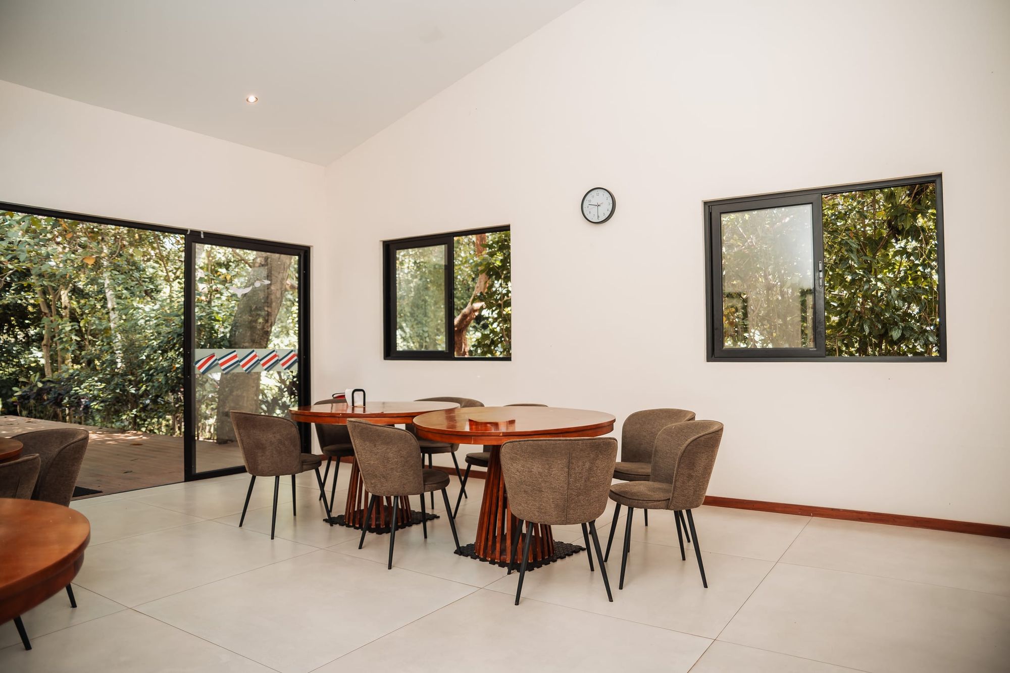 A wide view of the bright dining room at Atenas, with sliding doors open to the garden.