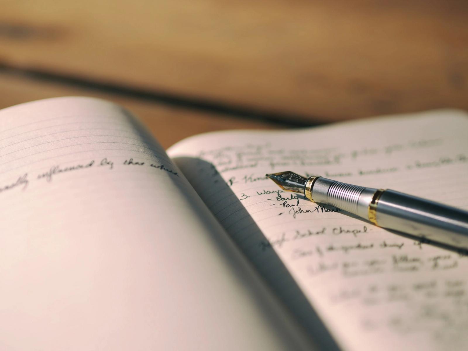 A pen resting on a page of handwritten notes.