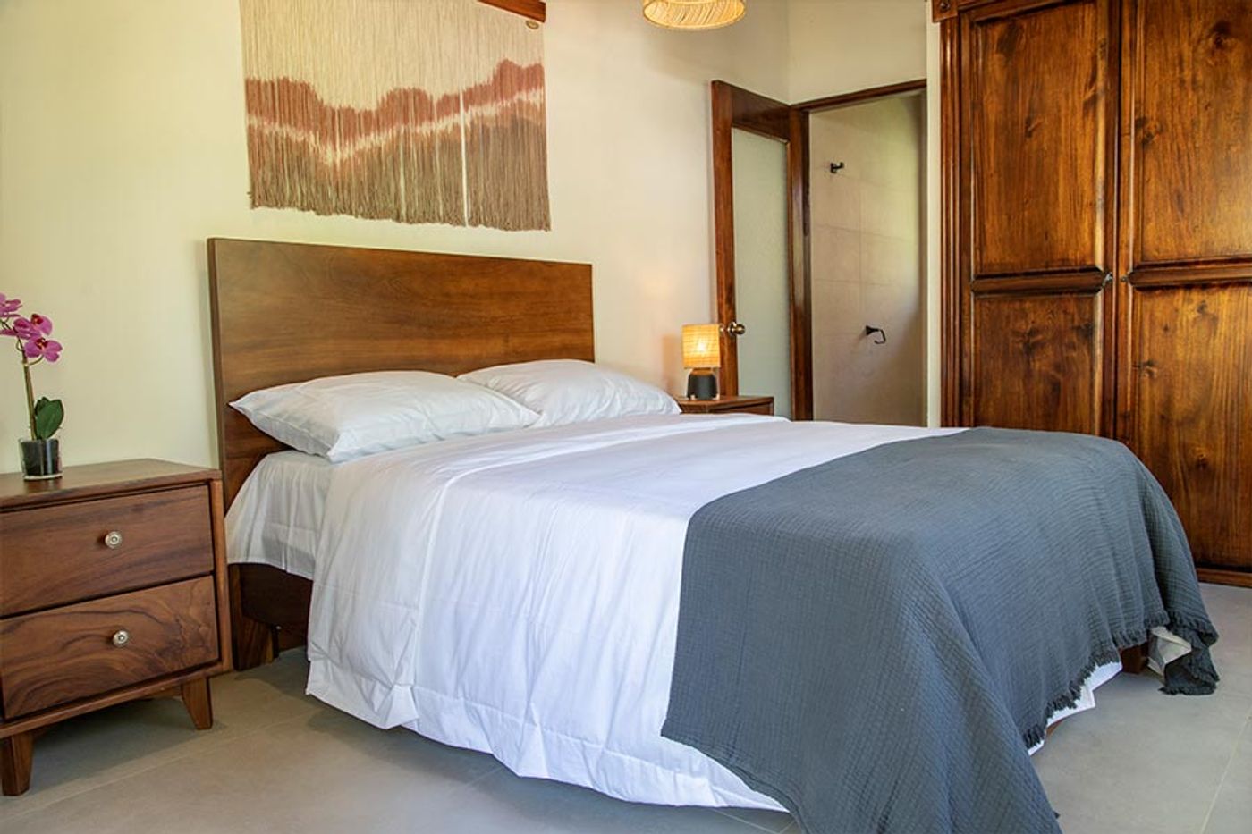 Private garden room. Wood-detailed furniture, queen bed, and ensuite bathroom door visible.