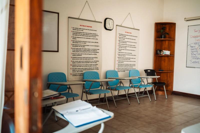 La sala grupal de San José, con sillas azules, textos enmarcados en la pared y un cuaderno sobre un escritorio.