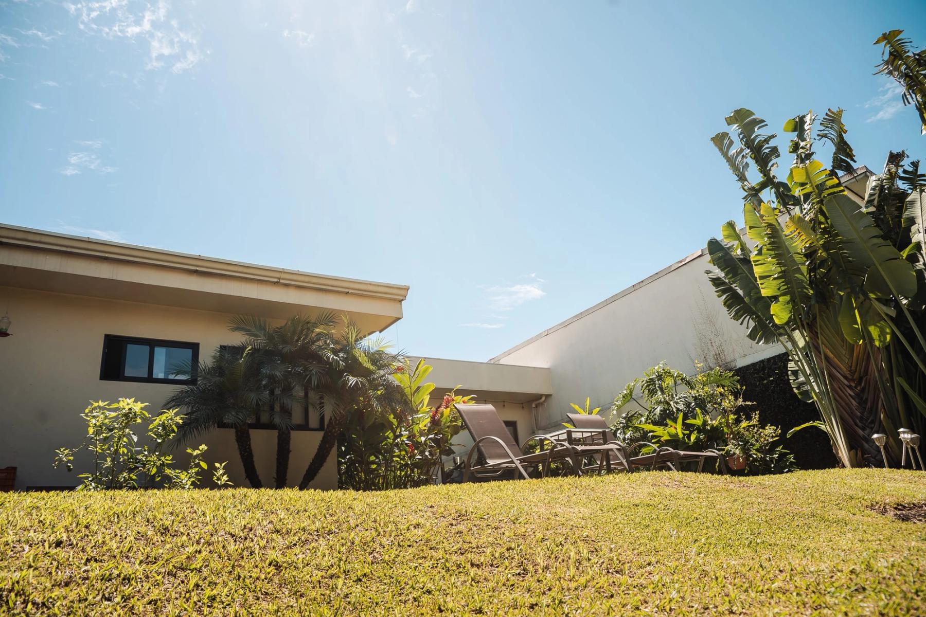 The San José residence seen across its lawn, with banana plants and palms at the edges.