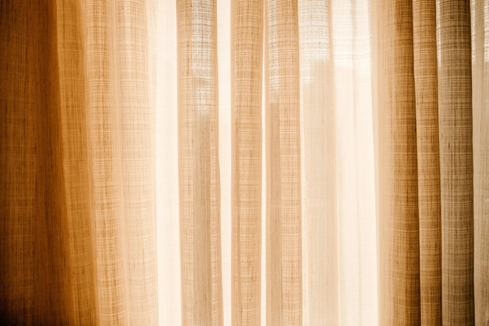 Warm sunlight glowing through a sheer curtain.