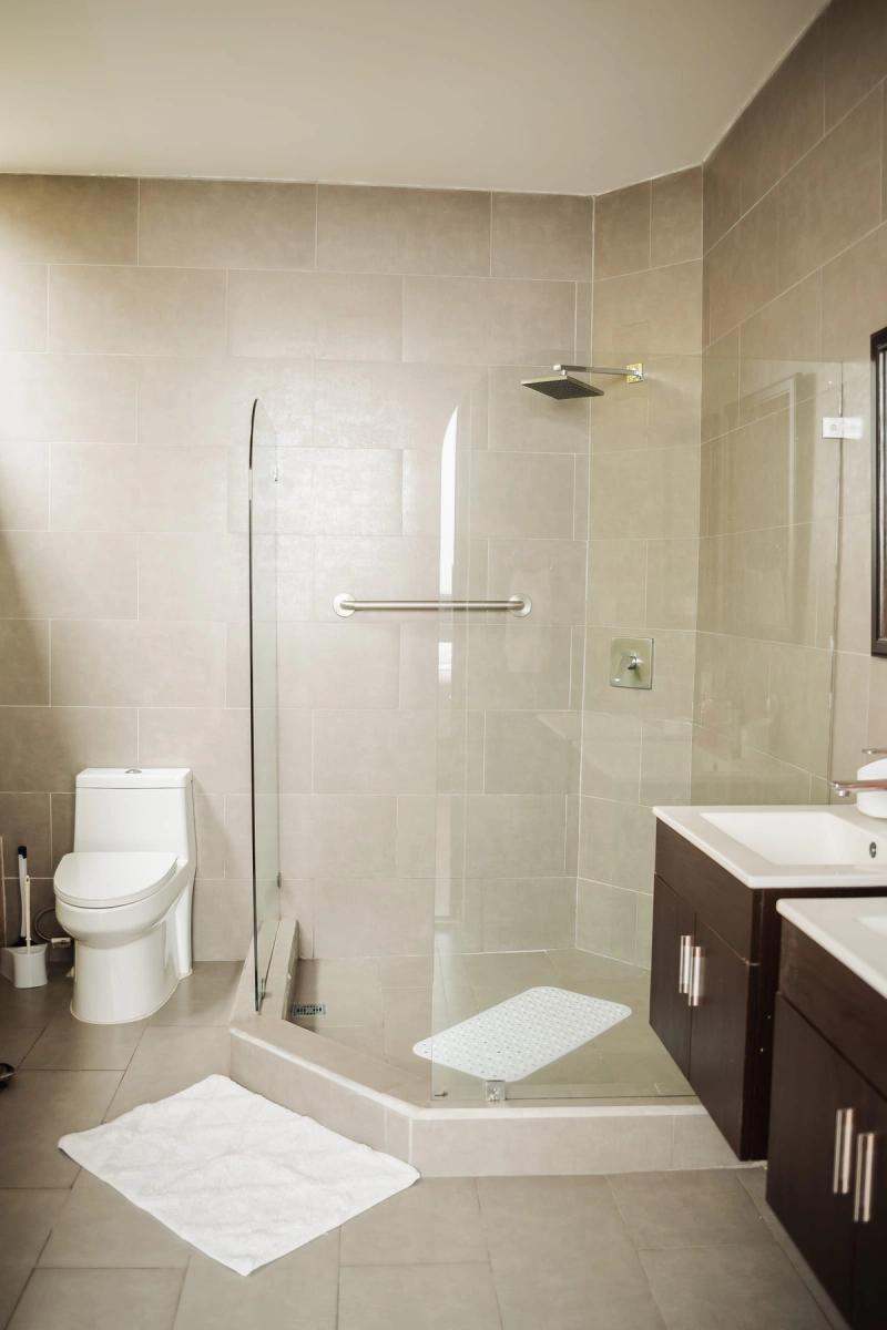 A private bathroom at San José with a glass shower and a dark wood vanity.