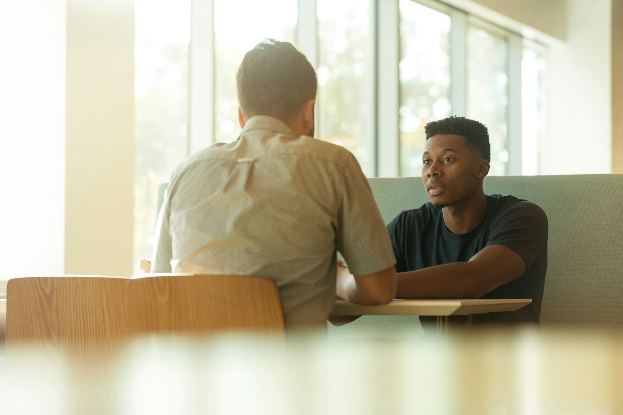 Two people in conversation, facing each other.