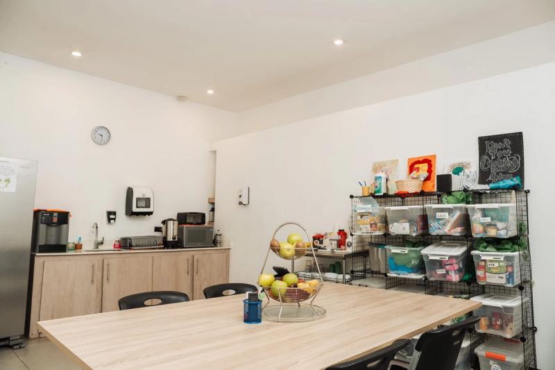 The kitchen at San José, with a shared table, a fruit basket and shelves of labeled bins.