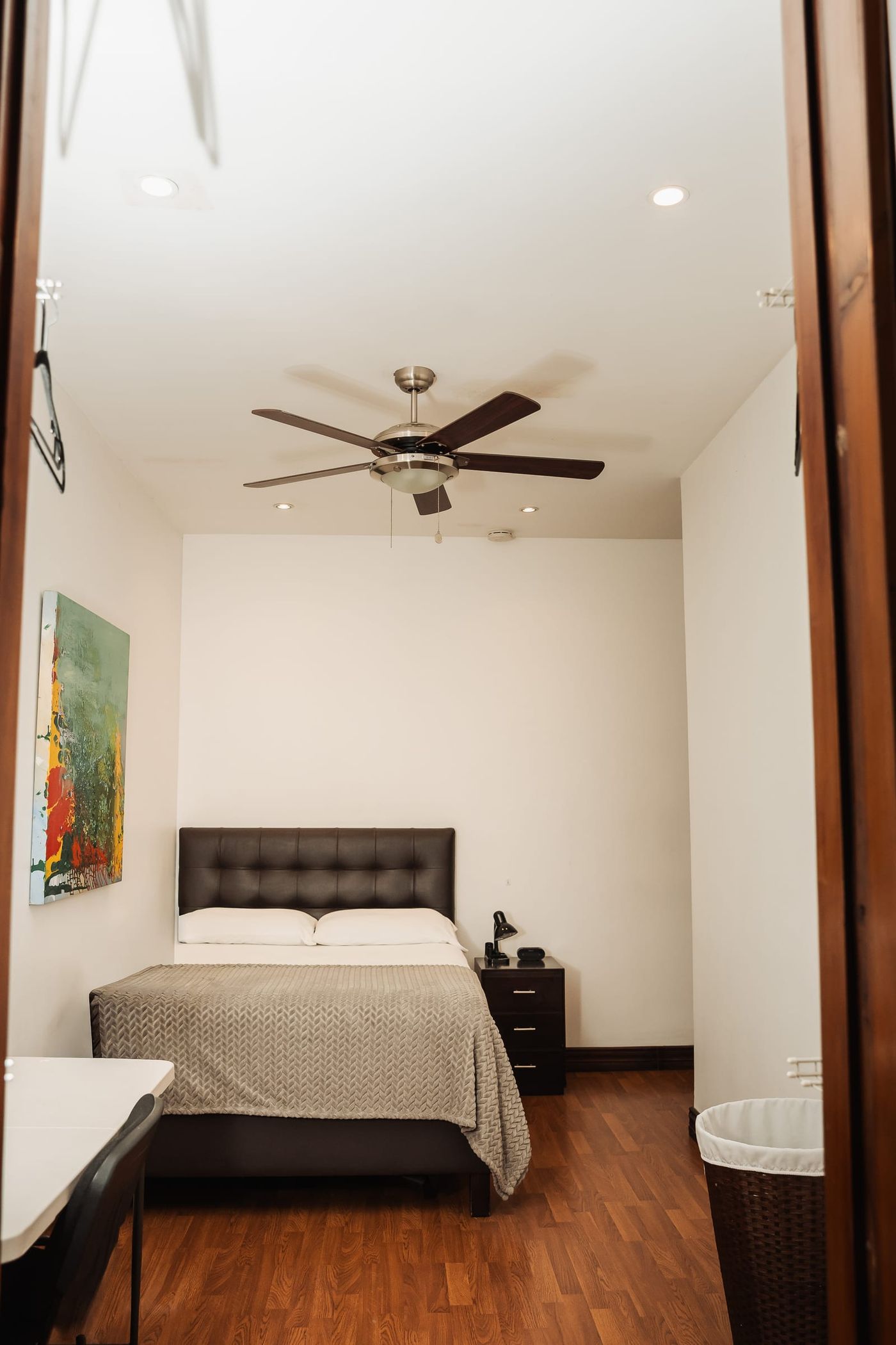 A private room at San José with a double bed under a ceiling fan.