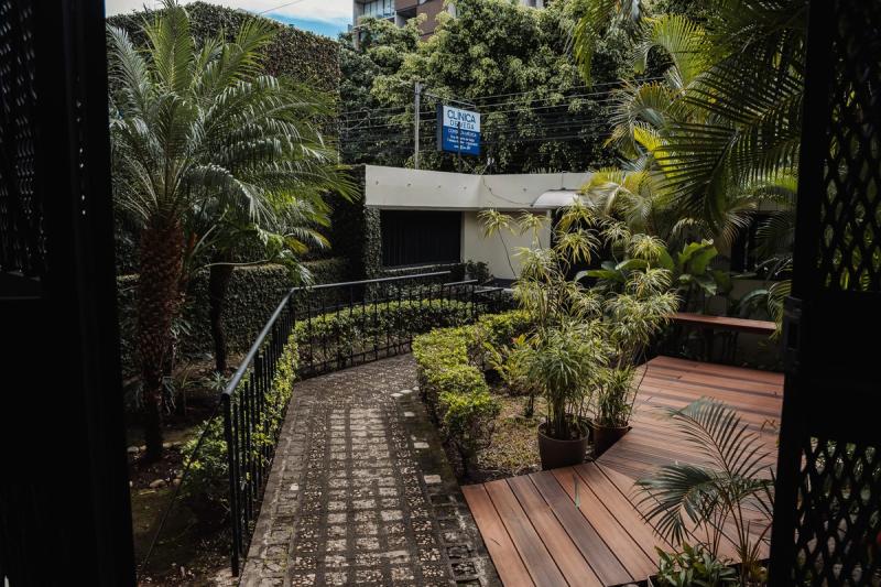 A tiled path and wooden deck winding through the planted garden at the San José residence.