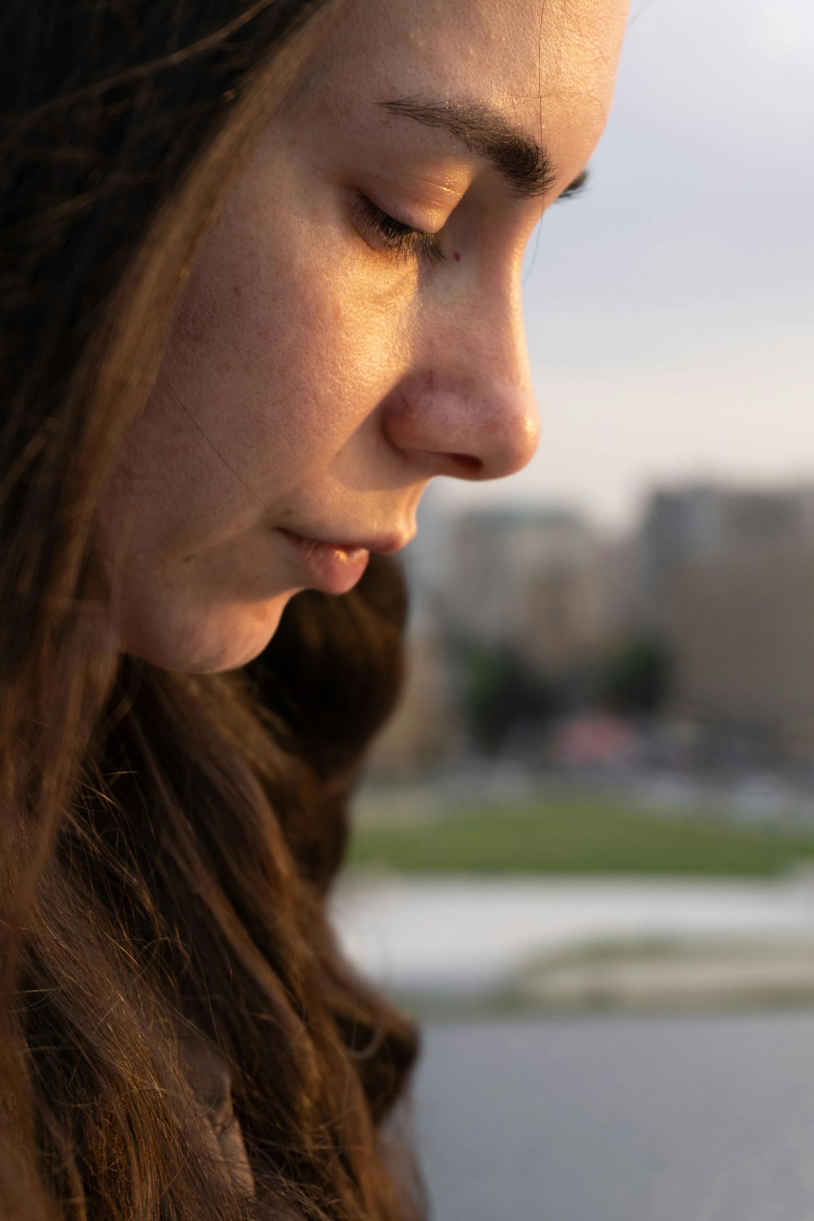 A person looking down in quiet contemplation.