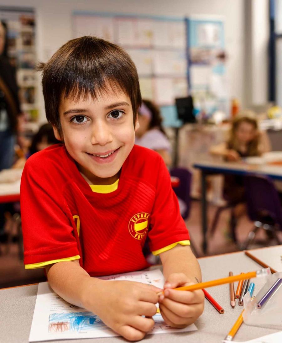 Senesh kindergarten student smiling during writing class.