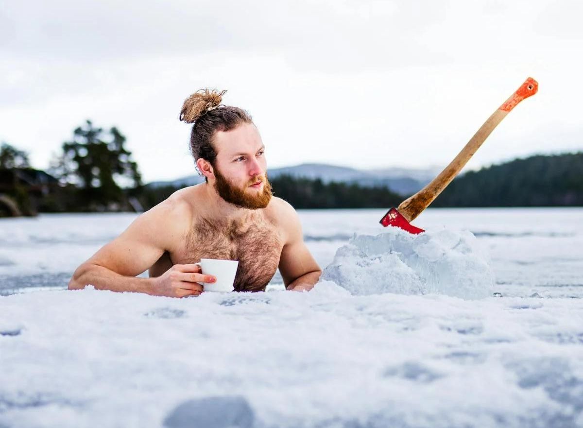 Man taking ice bath in a frozen lake, embracing the benefits of ice baths for energy, muscle recovery, and relaxation. Discover the best time of day to cold plunge—morning, afternoon, or evening—for maximum health benefits.