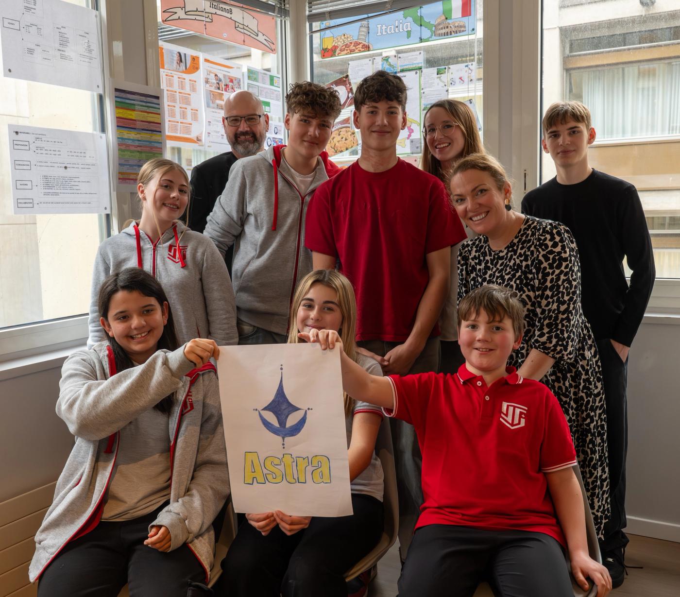 ISS primary and secondary students with their teachers, holding a student-designed poster