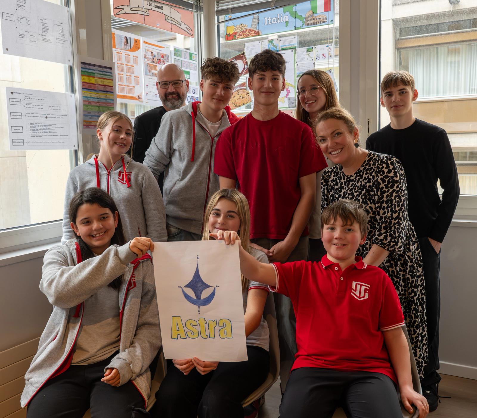 ISS primary and secondary students with their teachers, holding a student-designed poster