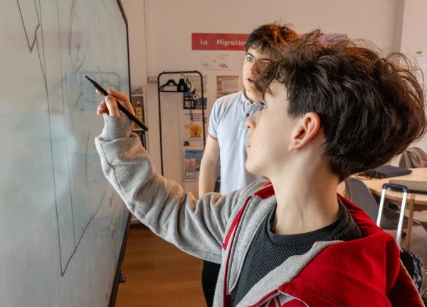 Two students solving a problem together at the interactive whiteboard