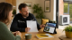 Qualified installer reviewing MCS certification paperwork for a British home with heat pump and solar panel planning notes.
