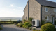 Rural British home replacing oil or LPG heating with an outdoor air to water heat pump under the Boiler Upgrade Scheme.