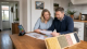 A UK landlord and retrofit advisor reviewing an EPC certificate and rental home upgrade plan.