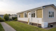 Residential park home being upgraded with external insulation in natural daylight.