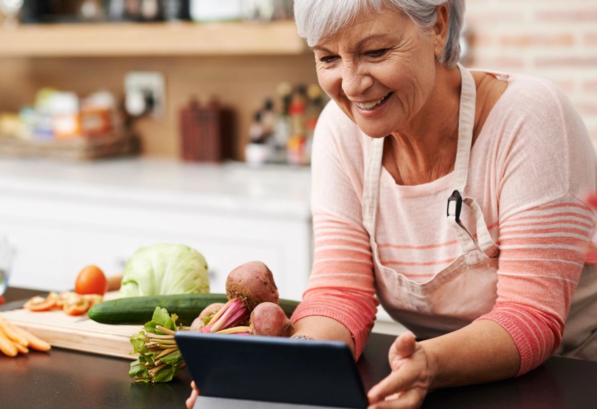 Idosa preparando refeição com acompanhamento nutricional