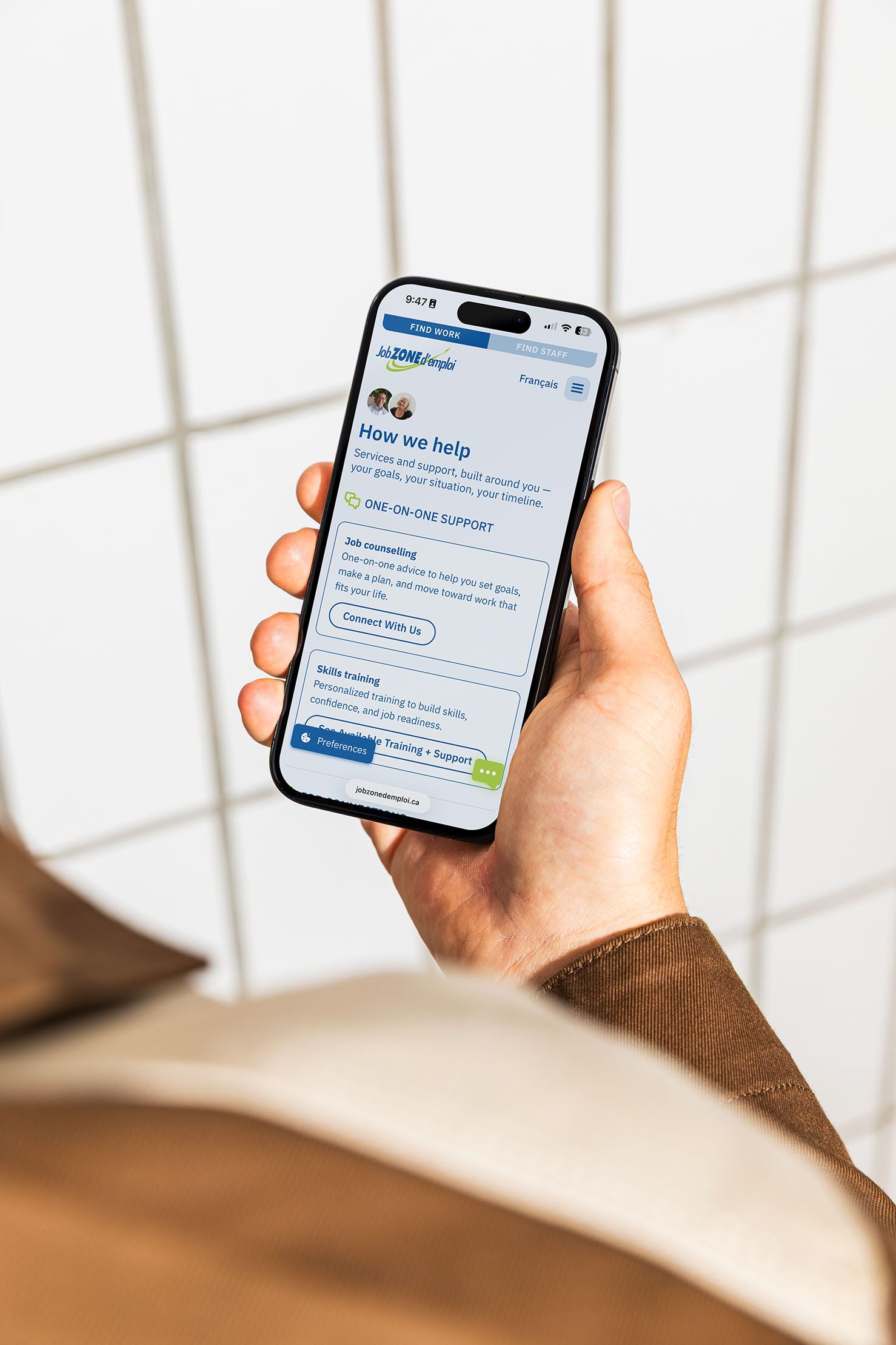 Person holding a phone looking at the Job Zone d'emploi website, which describes their services and how they can help. 