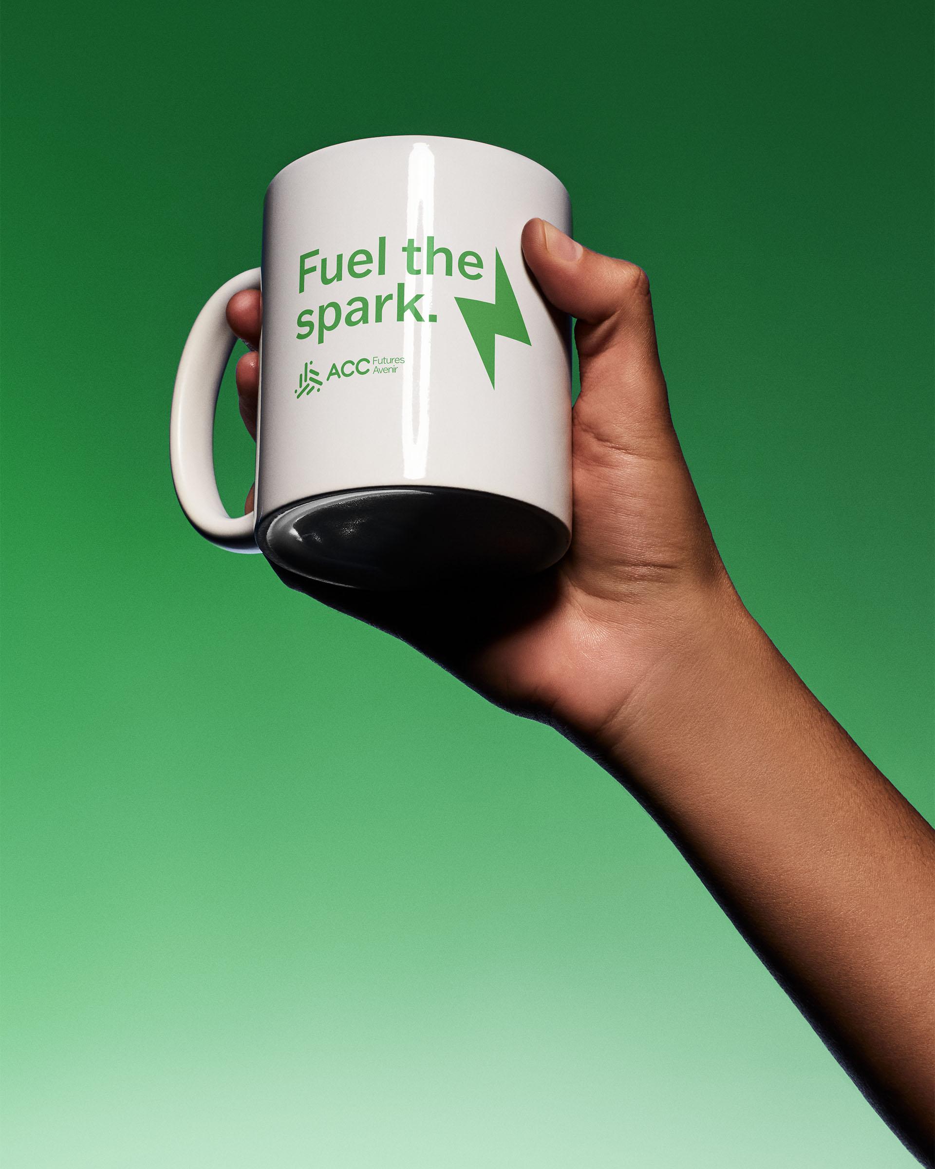 Person holding a white mug with text that says "Fuel the spark." with the ACCFutures logo and lightning bolt.
