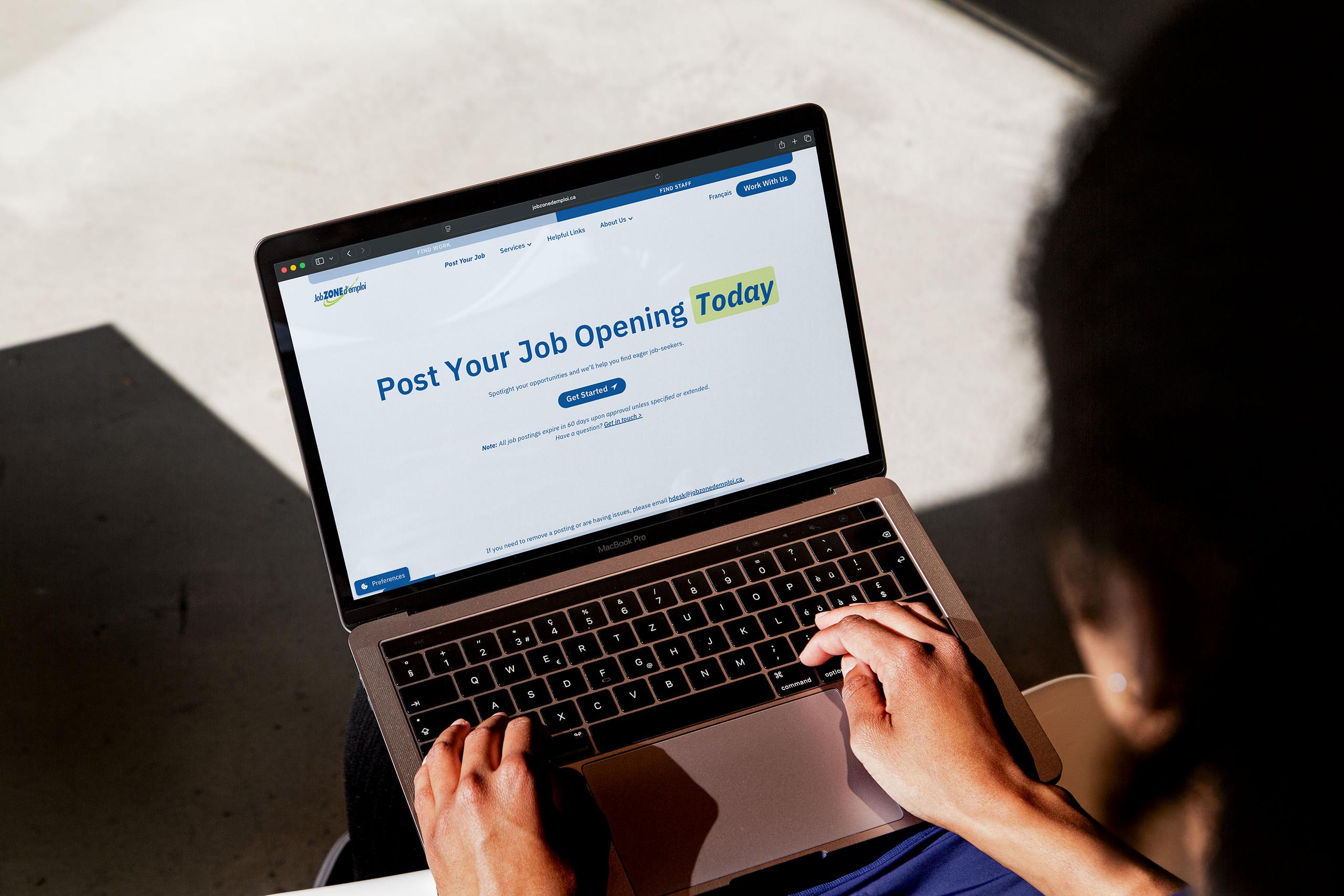 Person using a MacBook and looking at the Job Zone d'emploi "Post Year Job Opening Today" page designed for employers.