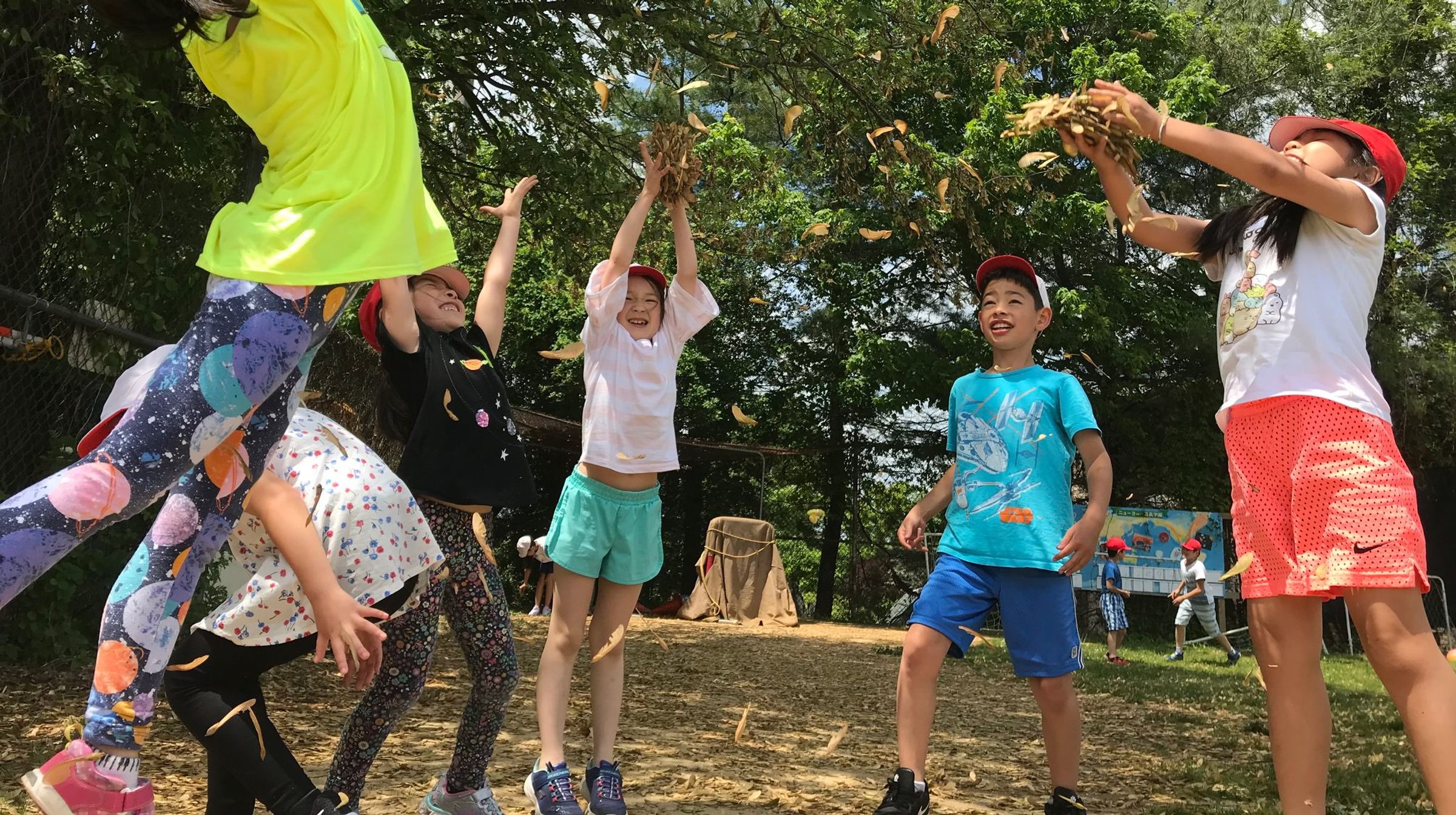 落ち葉を投げて遊ぶ生徒たち