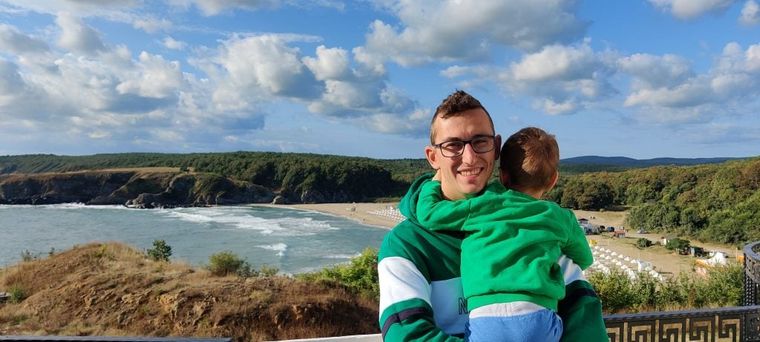 A happy man holding his son at the seaside