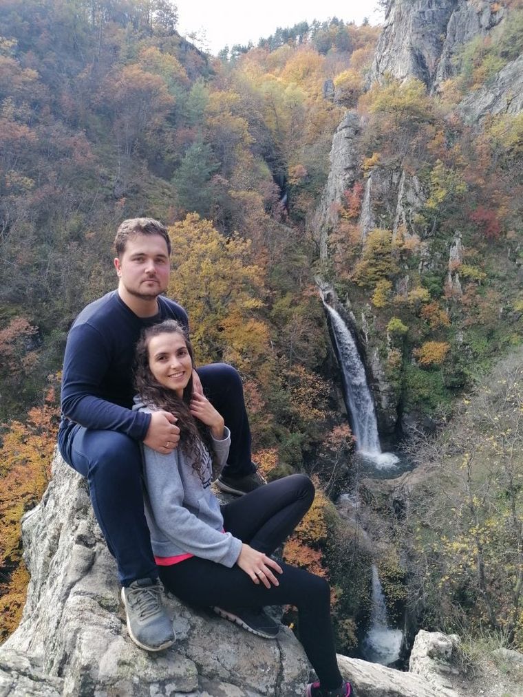 happy young-couple-sitting-on-a-rock-somewhere-in-the-nature