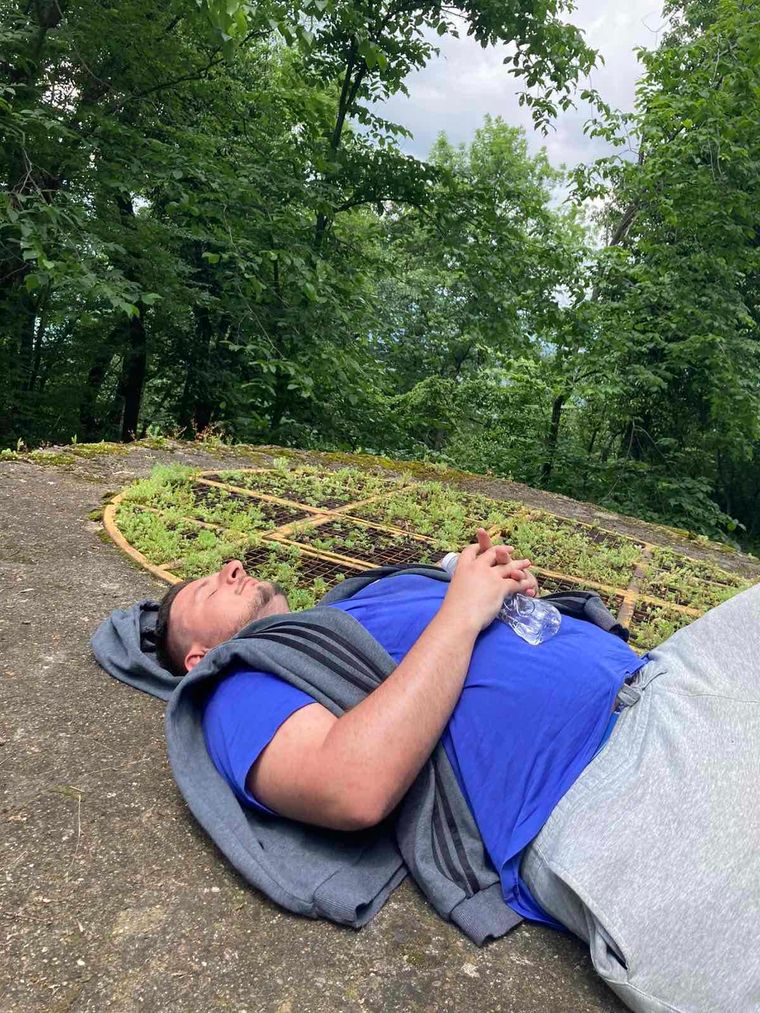 man-laying-on-the-ground-in-the-forest