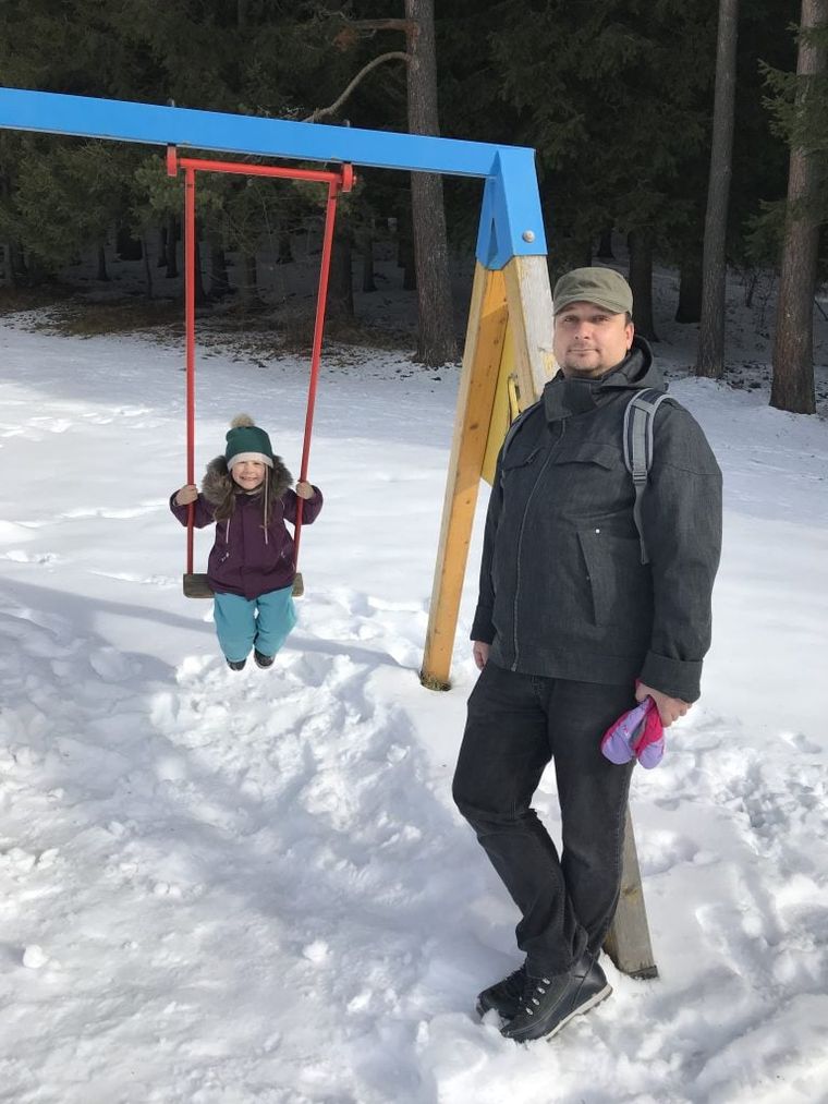 man-with-girl-at-swing-in-forest