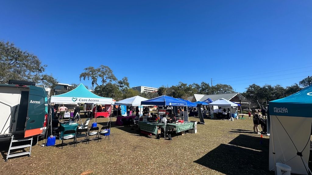 Wide shot of an outdoor community health fair with Care Access booth