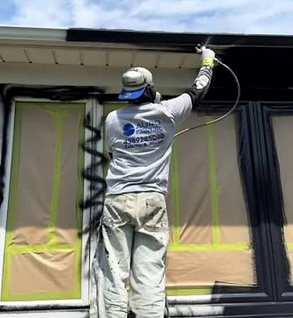 Real service work photo showing a technician working on the exterior of a property.