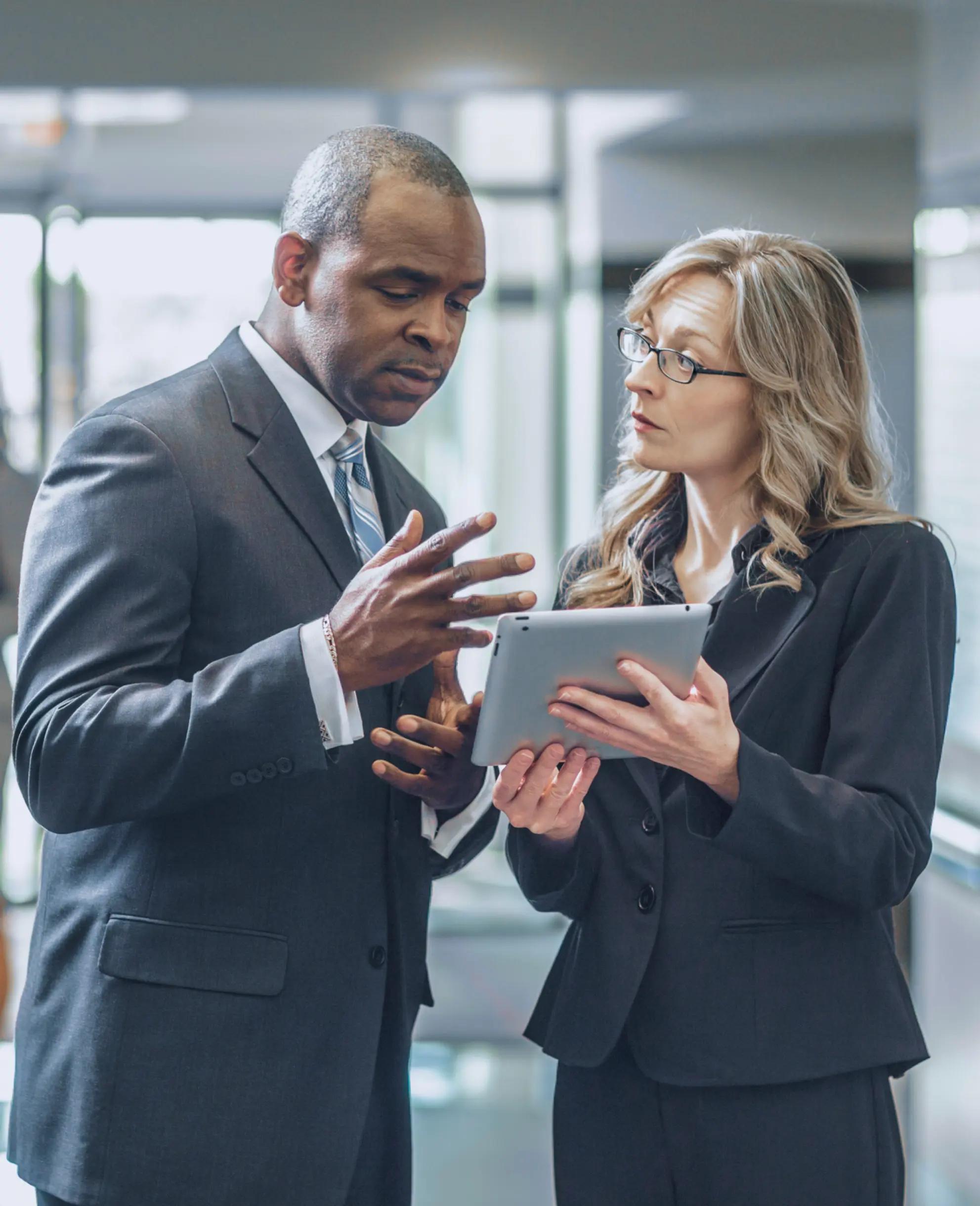 Two colleagues reviewing learning content on a tablet