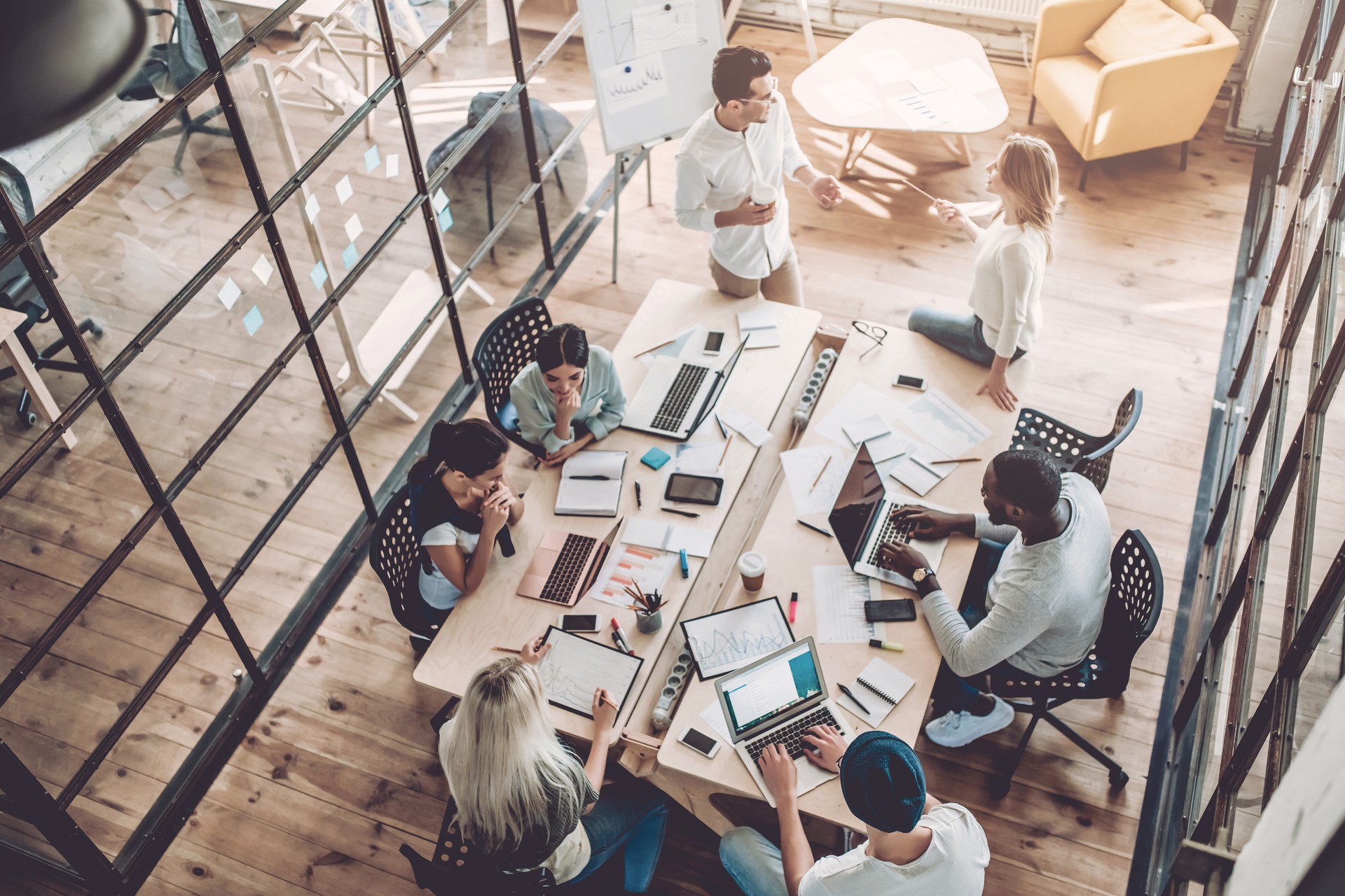 Overhead view of a team working and collaborating in a modern open-plan office.