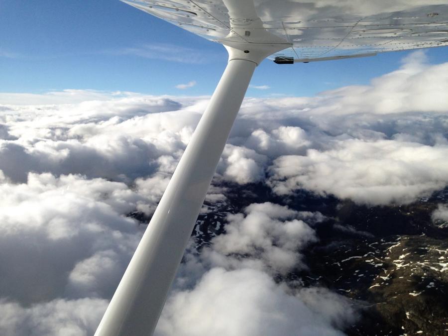 Fjell skimtes under hull i skylaget