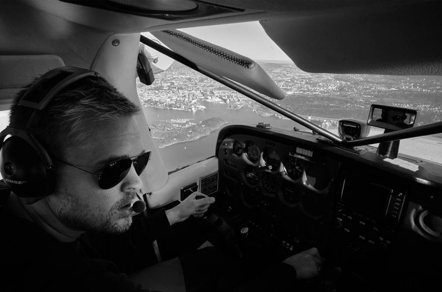 Anders i cockpit i en Cessna 172, med utsikt over Oslo og Oslofjorden. Sort/hvitt bilde.