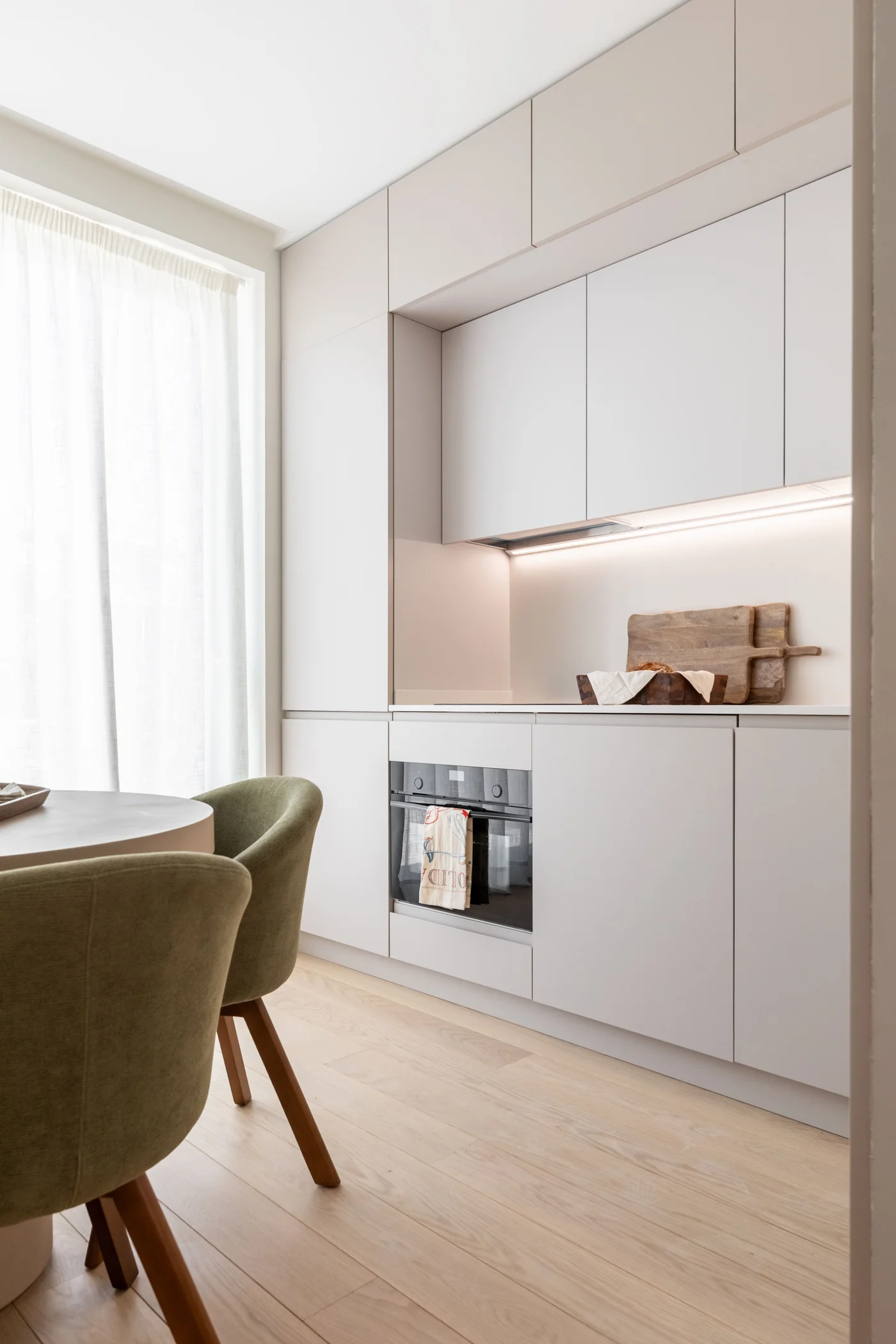 Cocina con frentes lacados y silla verde